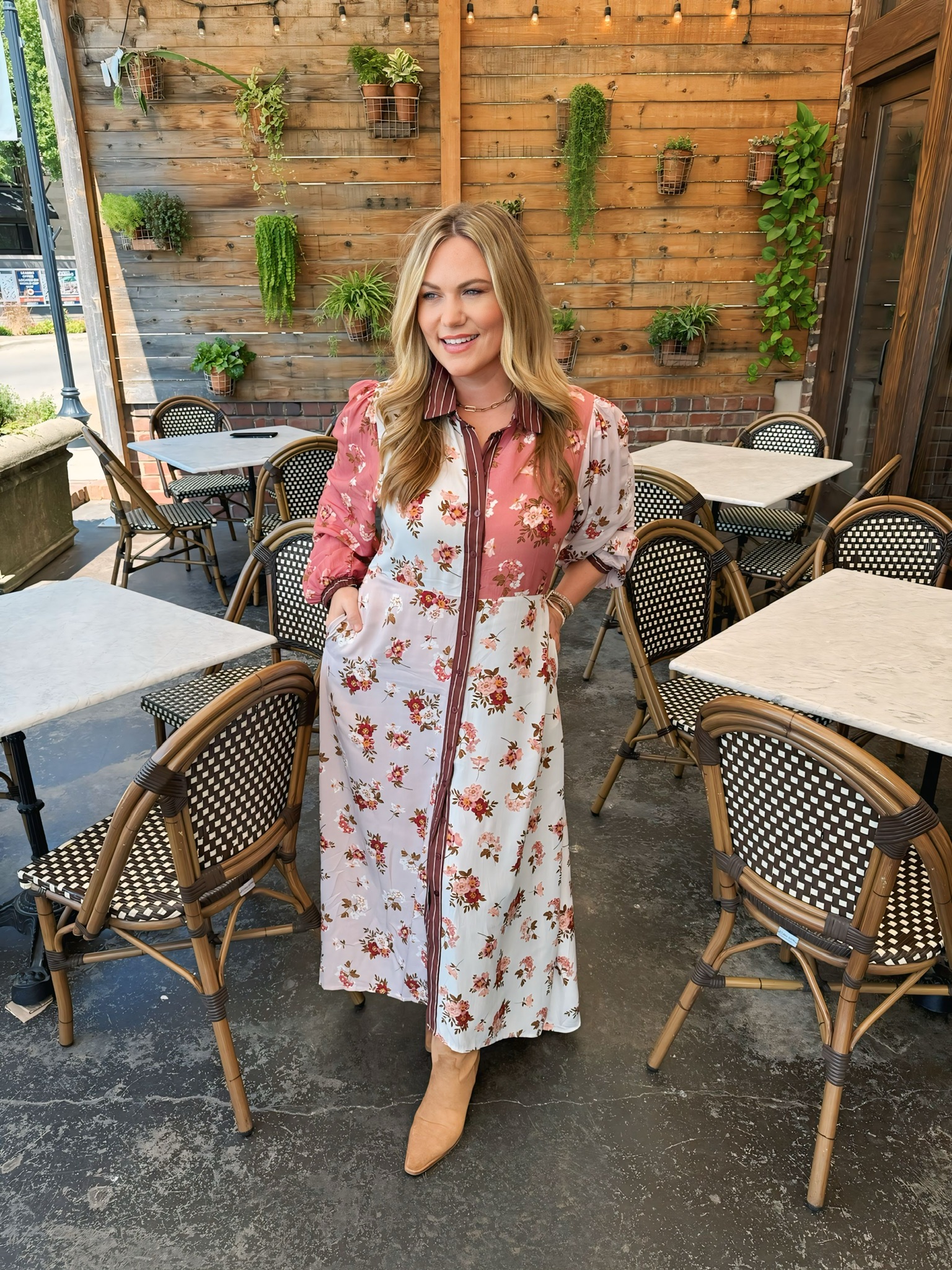 Audrie Dollins wearing floral print maxi dress and suede boots on café patio.