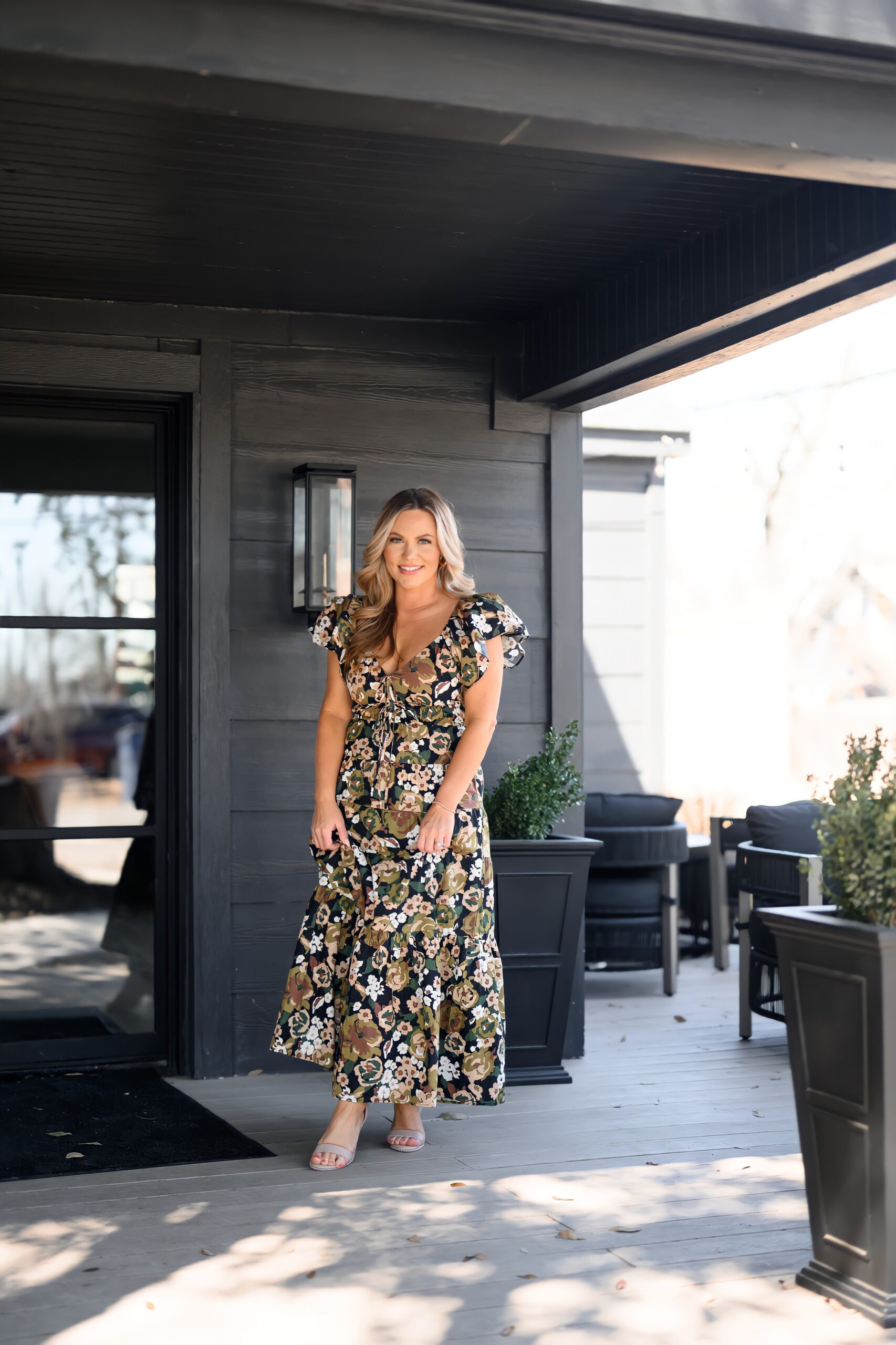 Audrie Dollins smiling outdoors in a long floral dress during a lifestyle photoshoot for her blog, sharing inspiration and entrepreneurial insights.