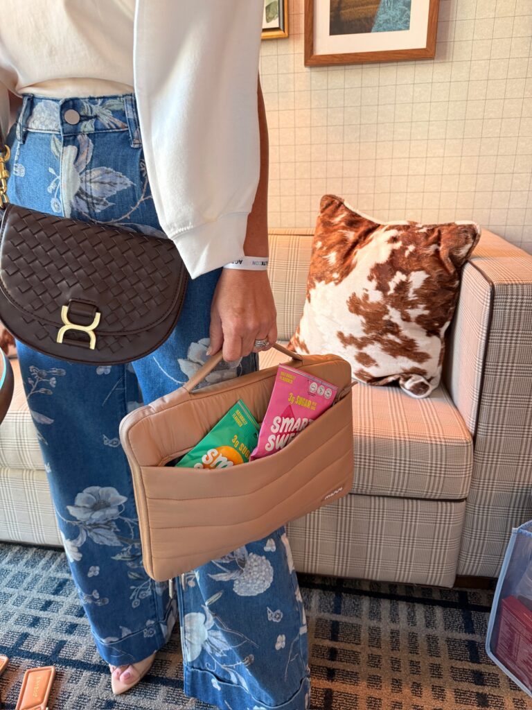 Audrie Dollins carrying Smart Sweets Peach Rings and Sourmelon Bites in an open handbag at LTKCon 2026, featuring a Parlay Collective snack brand collaboration and influencer gifting partnership.