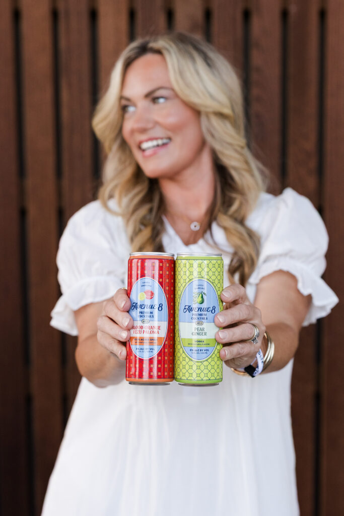 Audrie Dollins holding two colorful Avenue 8 canned beverages at LTKCon 2026 in Frisco, Texas, showcasing a Parlay Collective brand partnership and influencer marketing collaboration.