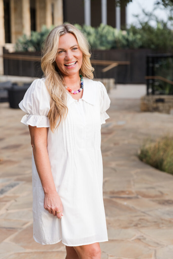 Audrie Dollins wearing a white dress and Parlay Collective branded sweater at LTKCon 2026, representing her Frisco-based influencer management and digital marketing business.